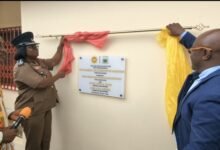 DCFO Ghanson (second from left) being assisted by Prof Amankwah (right) to unveil the UMaT fire station