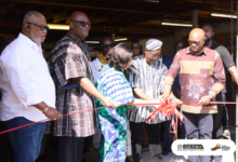 Mr Arthur (fourth from left) being assisted by Mr Dogbe (right) and Ms Benson (middle) to cut the tape to open the Trade House. With them is Mr Madjie (second from left)
