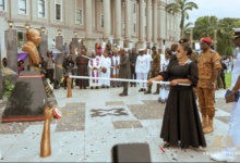 President Mahama and the wife of the late Dr. Edward Omane Boamah lighting a perpetual flame at the unveiling of a cenotaph in honour of the late Defence Minister