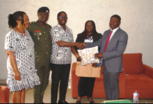 Mr Eshun(middle) presenting a gift to Dr Nai during the visit. With them are Mrs Georgina Quaittoo (second from right), Rev Canon Dr Lt Col Lokko (second from left) and Ms Elizabeth Tetteh Photo Victor A. Buxton.