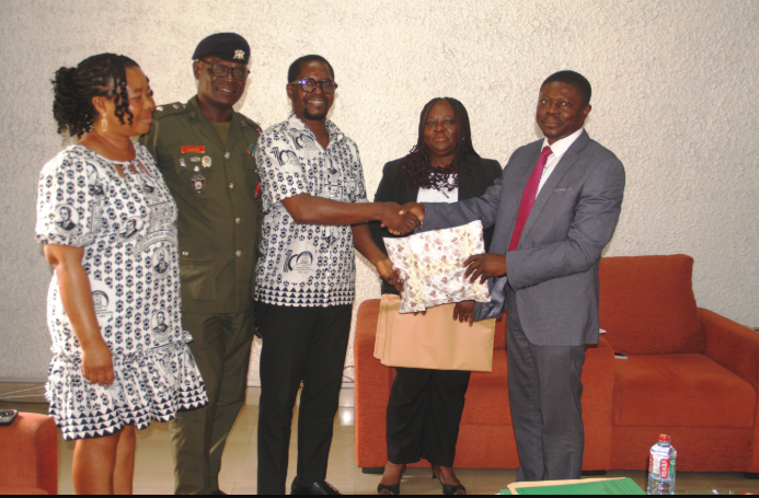 Mr Eshun(middle) presenting a gift to Dr Nai during the visit. With them are Mrs Georgina Quaittoo (second from right), Rev Canon Dr Lt Col Lokko (second from left) and Ms Elizabeth Tetteh Photo Victor A. Buxton.