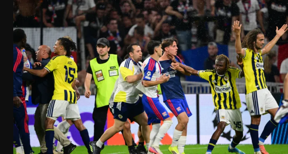 Fenerbahce's Nene Dorgeles tries to seperate teammates Matteo Guendouzi (R) and Lyon's players