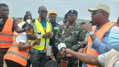 Mr Omani-Mensah (wearing a yellow reflector and standing second from left), briefing Mr Ayariga (right)
