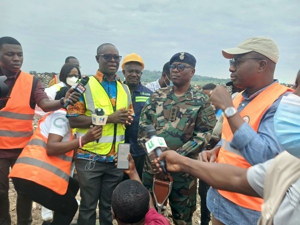 Mr Omani-Mensah (wearing a yellow reflector and standing second from left), briefing Mr Ayariga (right)