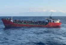 A cargo ship carries migrants during a rescue operation as it sails off the island of Crete, Greece