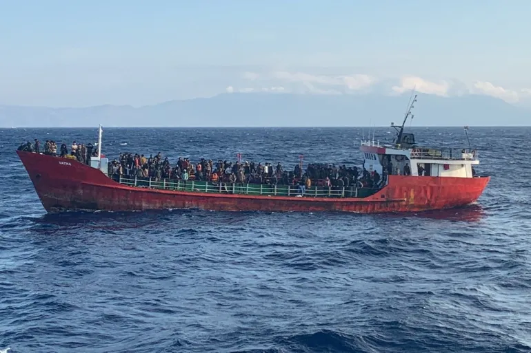 A cargo ship carries migrants during a rescue operation as it sails off the island of Crete, Greece
