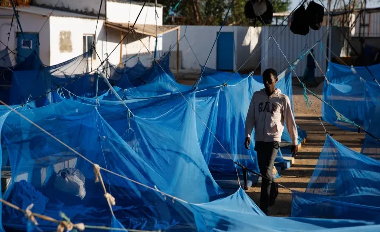 A man walks through a male dormitory at an International Organization for Migration transit centre for migrants in Obock, Djibouti