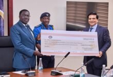 Dr Yamborigya (middle) receiving the dummy cheque from Mr Thakwani (right)