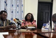 Mr Atasige, (in smock) addressing the news conference