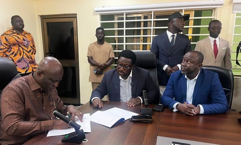 Mr Opoku (left) with Mr Adimado and others during the signing ceremony