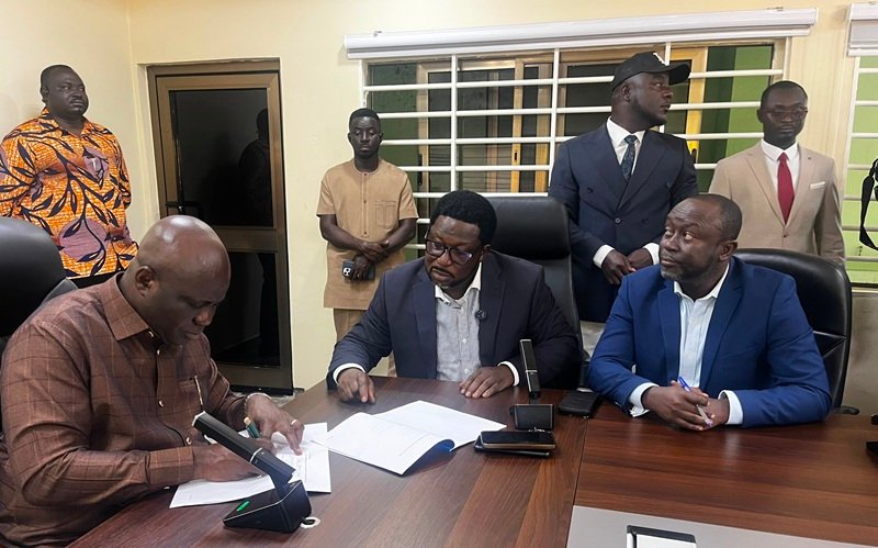 Mr Opoku (left) with Mr Adimado and others during the signing ceremony