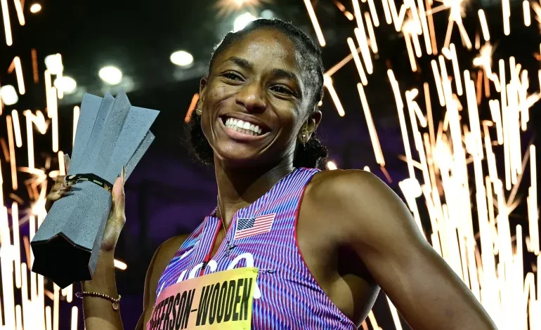 Melissa Jefferson-Wooden celebrates with the trophy after winning the 200m final