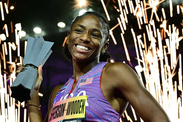 Melissa Jefferson-Wooden celebrates with the trophy after winning the 200m final