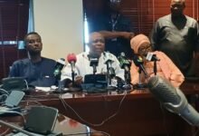 Mr Agalga (middle) speaking at the press briefing