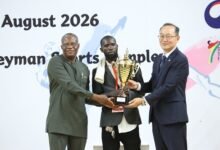 Mr Lartey Otu (left) and Mr Kyongsig presenting a trophy to a coach of the Greater Accra team