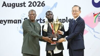 Mr Lartey Otu (left) and Mr Kyongsig presenting a trophy to a coach of the Greater Accra team