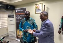 Mr Opoku (left) receiving the cheque from Mr Biswas at the ceremony