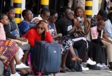 Stranded travellers wait with their luggage after flight operations were disrupted due to the strike