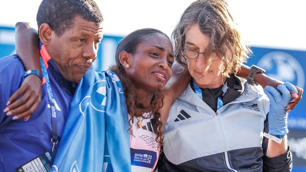 Tigst Assefa receives support at the finish line after suffering from cramps