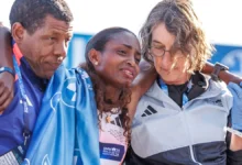 Tigst Assefa receives support at the finish line after suffering from cramps