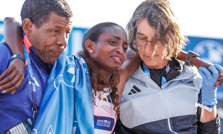 Tigst Assefa receives support at the finish line after suffering from cramps
