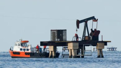 Workers of Venezuelan state oil company PDVSA labour at an operating pumpjack in Lake Maracaibo, in Cabimas, Venezuela
