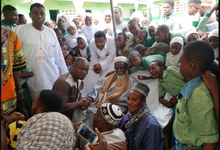 Mr Issah in a handshake with Sheikh Dr Osman Nuhu Sharubutu during their meeting. With them are pupils from AFRAMISCO