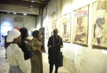Mr Wayo (right) explaining the meaning of the exhibited works .