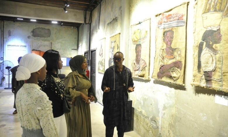 Mr Wayo (right) explaining the meaning of the exhibited works .