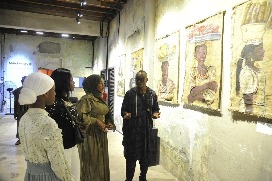 Mr Wayo (right) explaining the meaning of the exhibited works .