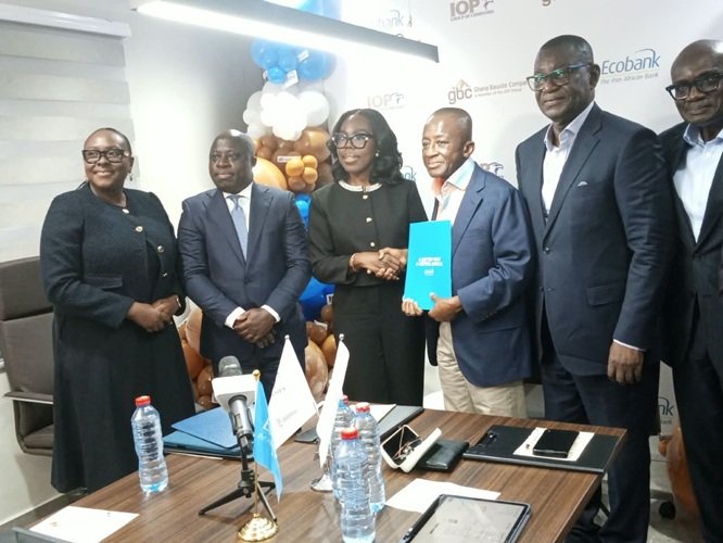 Mr Ofori-Poku (third from right) exchanging the signed document with Mrs Osei-Poku, while officials of the two organisations look on