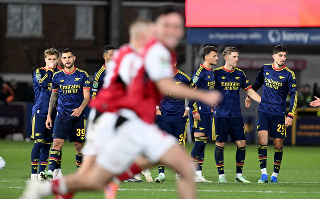 Dejected Arsenal players look on as Fleetwood players celebrate