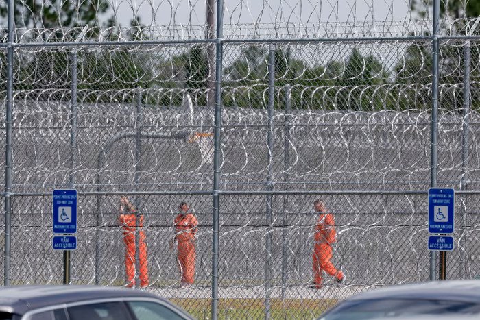 Detainees behind concertina wire inside the Folkston facility