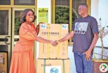 Ms Obuobia Darko-Opoku (left) presenting the items to a beneficiary representative at the event