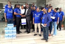 Mr. Appiah Otoo (second from left) presenting the water to Mr. Delali Gaisi (third from right, front row)