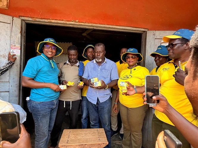 MTN staff presenting a gift to a customer