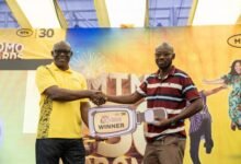 MTN rewards 3 customers ------One of the winners receiving his prize at the presentation ceremony