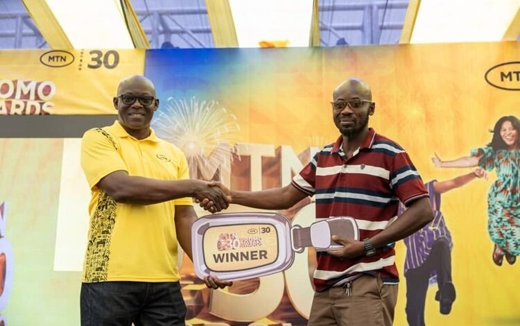 MTN rewards 3 customers ------One of the winners receiving his prize at the presentation ceremony