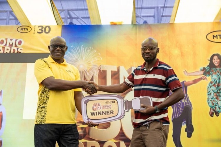 MTN rewards 3 customers ------One of the winners receiving his prize at the presentation ceremony