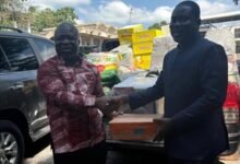 Mr Klu (right) presenting the items to Mr Gunu
