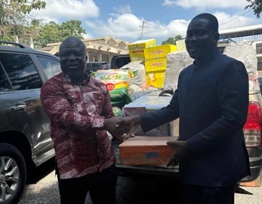 Mr Klu (right) presenting the items to Mr Gunu