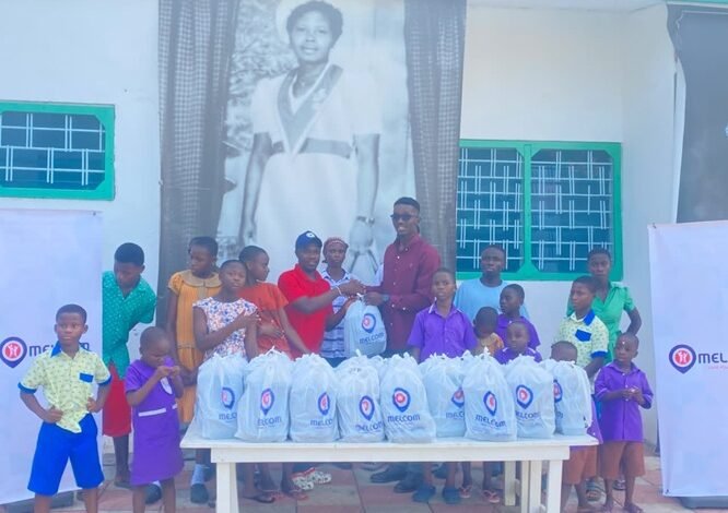 Mr Kpormegbey (right, back row) presenting the packed meals to the children