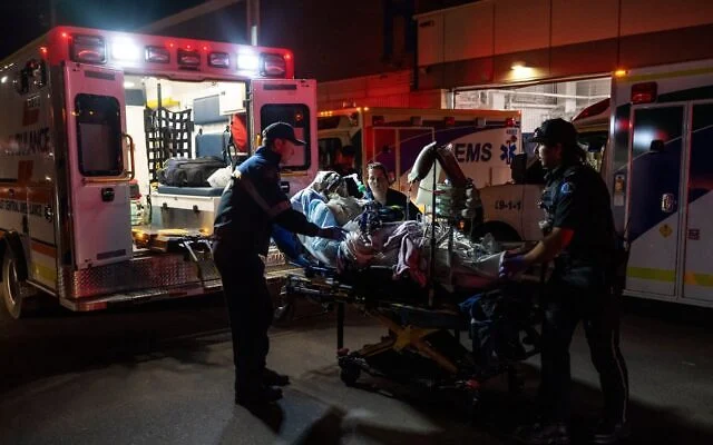 Paramedics load an injured person into an ambulance at the Wainwright Health center