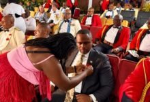Mr Gilbert Adjei having a poppy pinned to his lapel after the launch