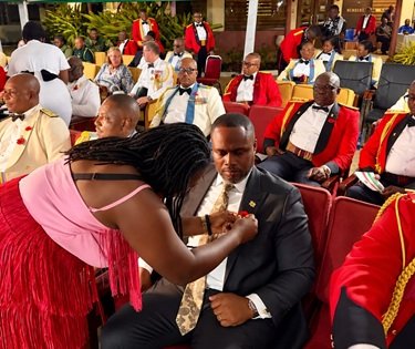 Mr Gilbert Adjei having a poppy pinned to his lapel after the launch