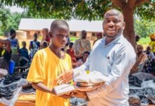 Mr. Sandoo (right) presenting the items to Master Musah, a beneficiary pupil at the school