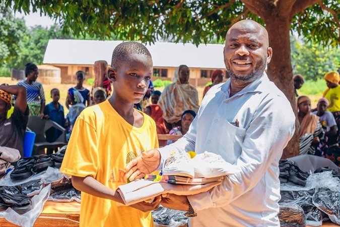 Mr. Sandoo (right) presenting the items to Master Musah, a beneficiary pupil at the school